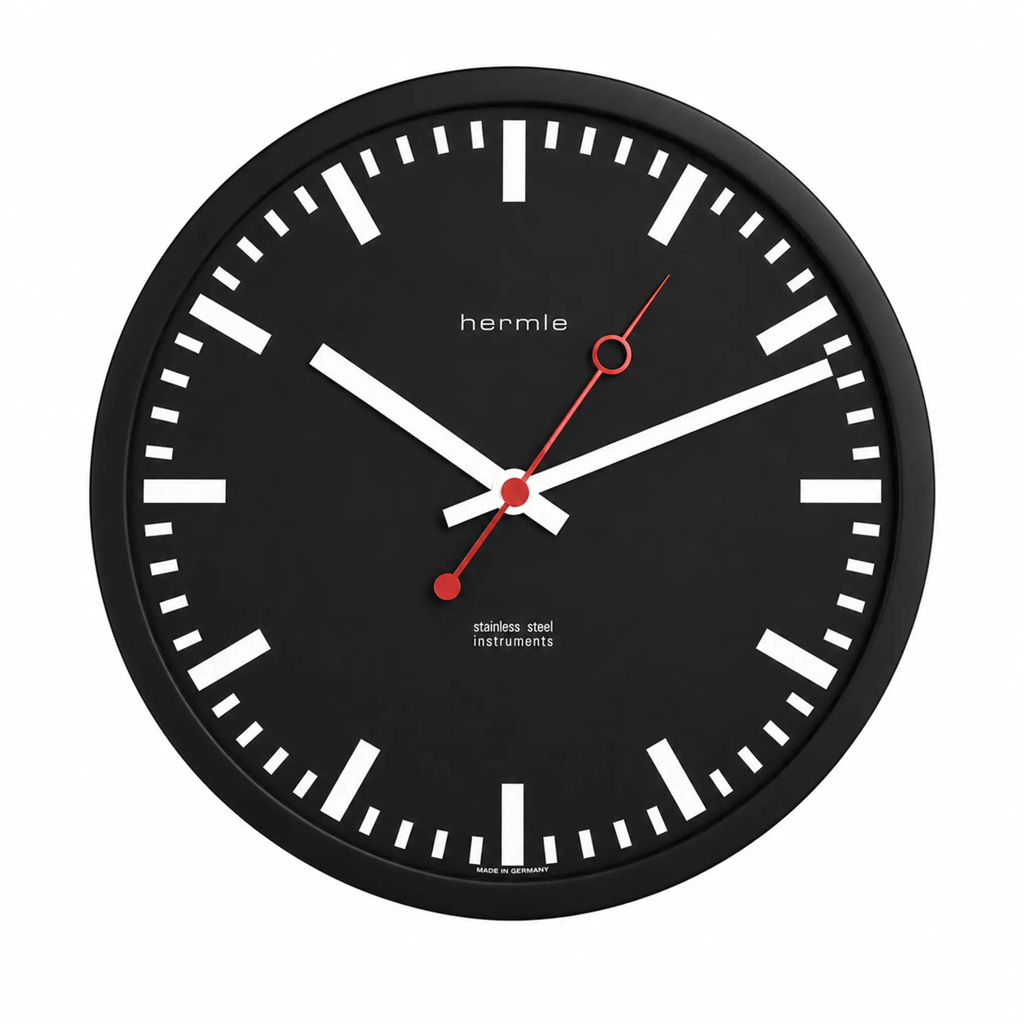 Reloj de pared: esfera negra, manecillas rojas, marcadores de índice blancos, marco redondo negro.