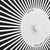 Vista frontal de un reloj de pared Hermle con patrón de rayos en blanco y negro y centro claro