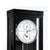 Esfera de reloj de pared en caja negra con números romanos y mecanismo de regulación visible.