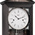 Primer plano de reloj de pared: esfera blanca con números romanos y manecillas negras